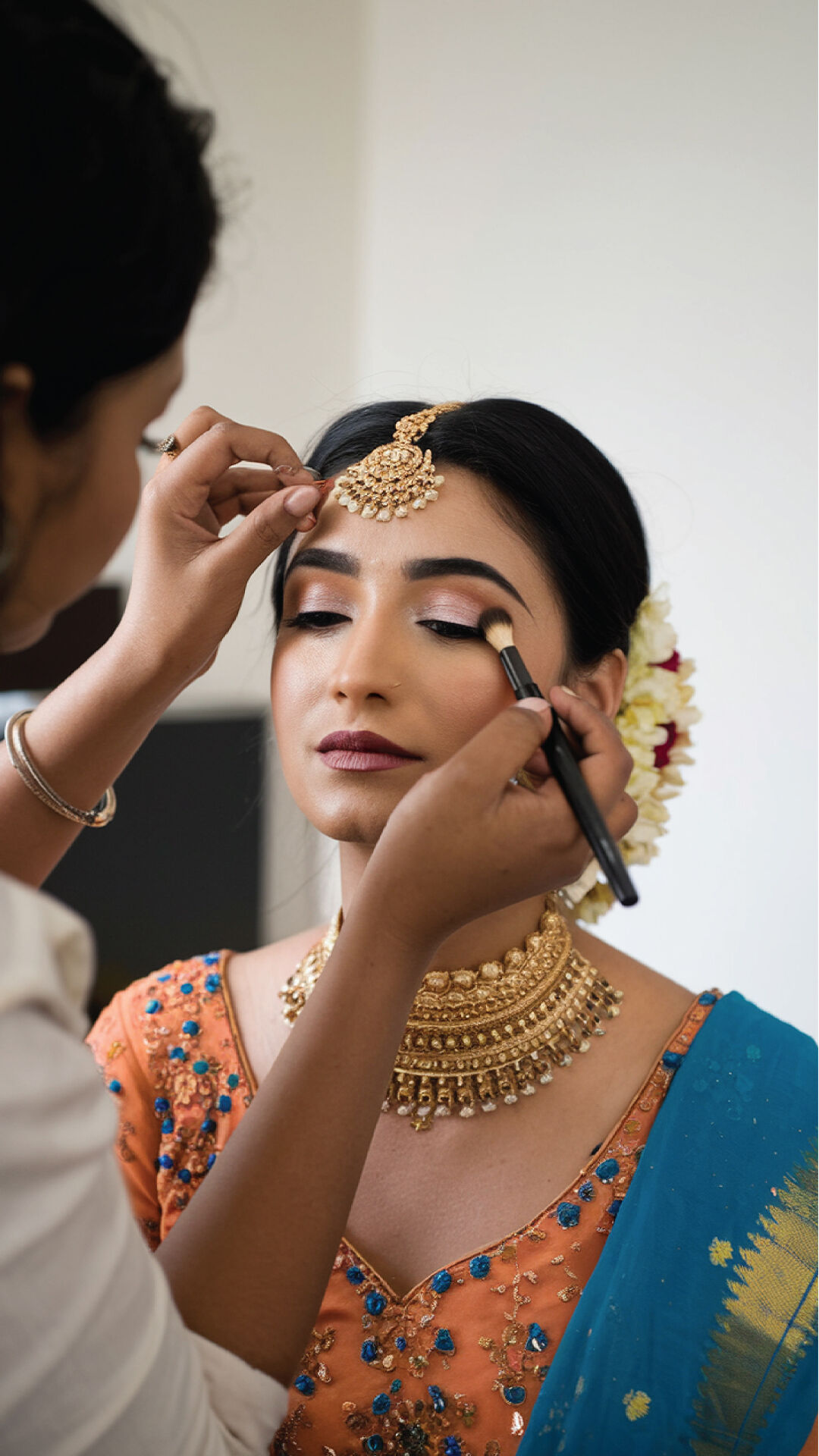 A bride getting eyr makeup done by maekup artist